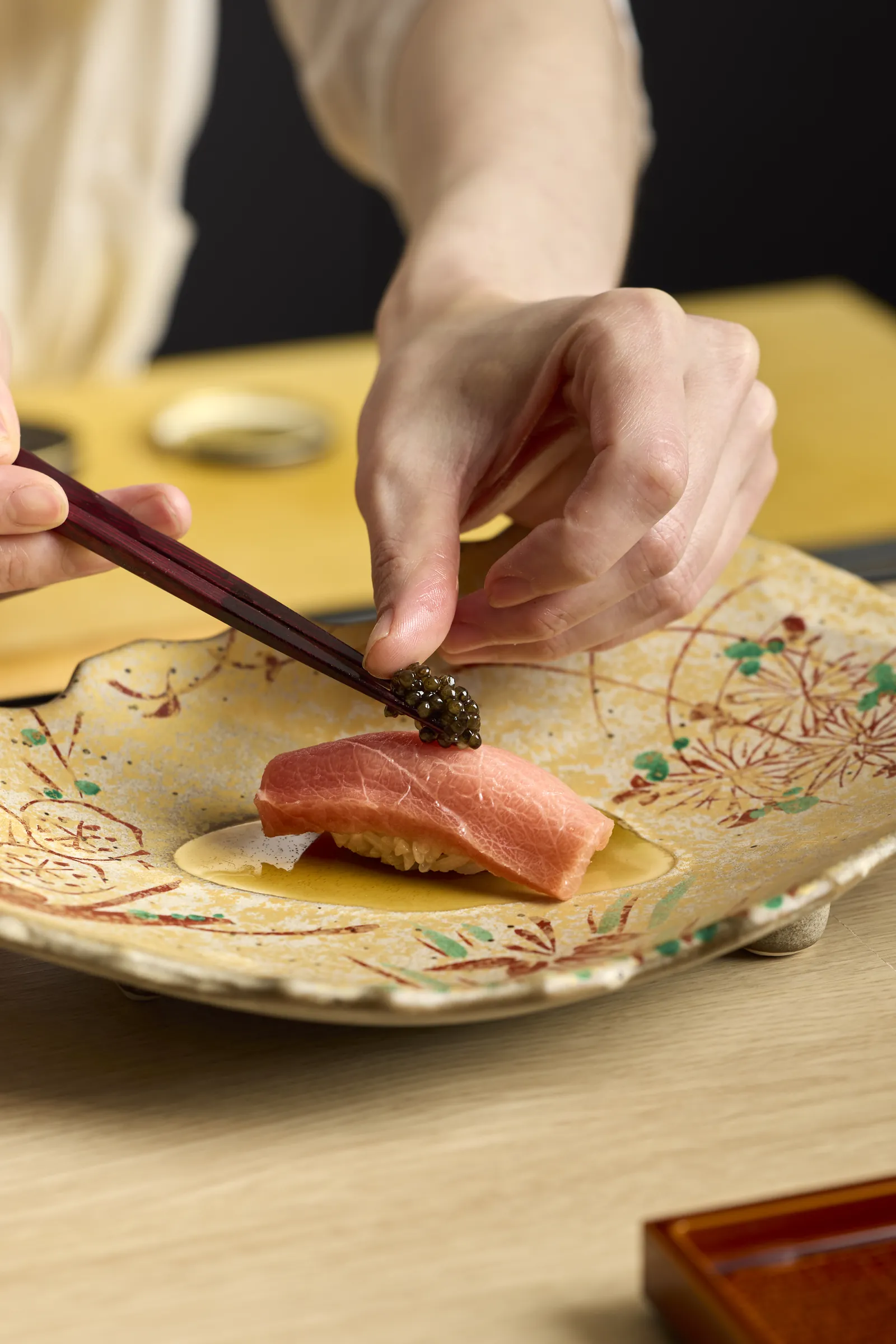 A seasonal omakase dish being finished with chopsticks